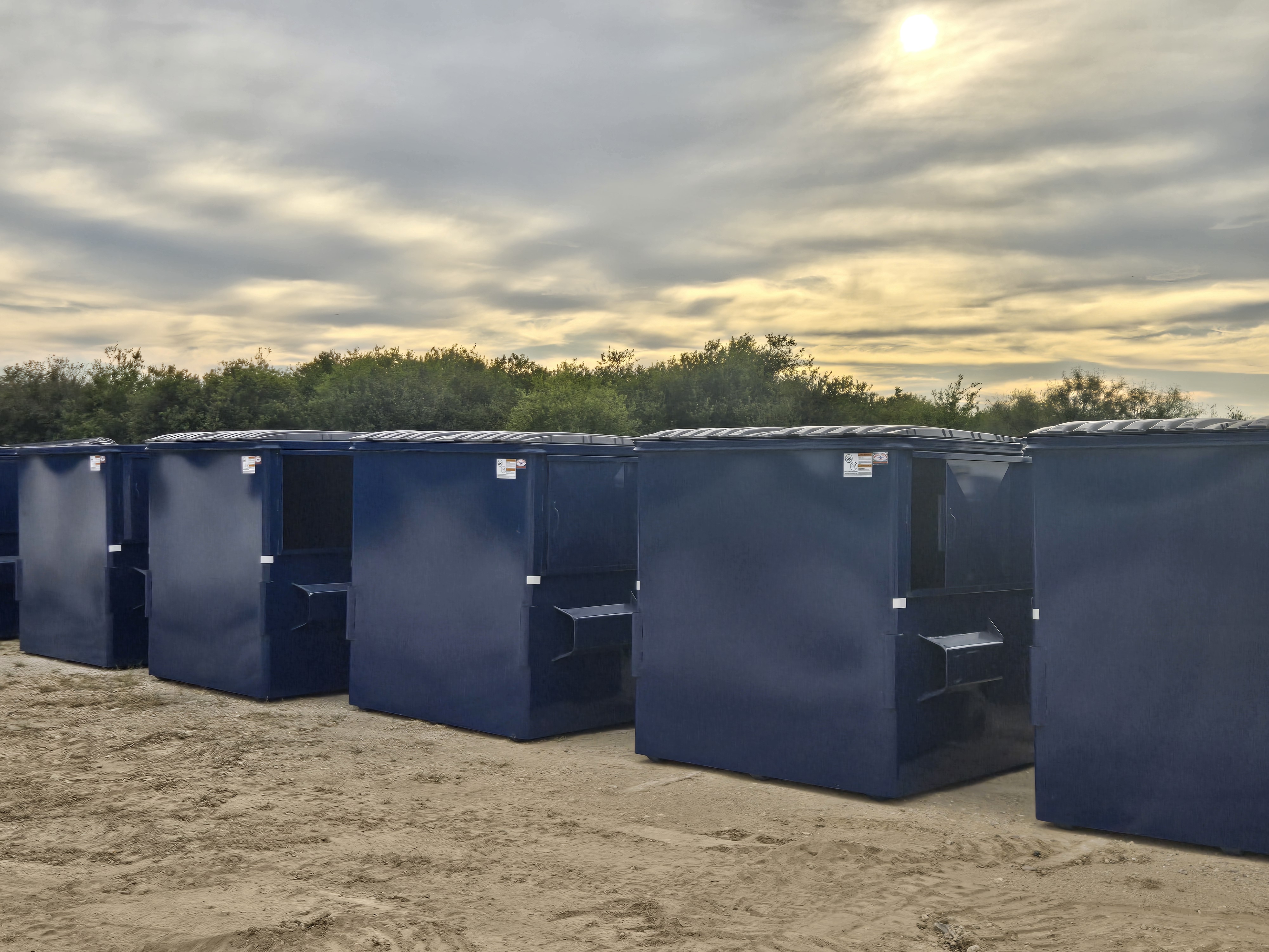 Commercial dumpsters lined up at facility
