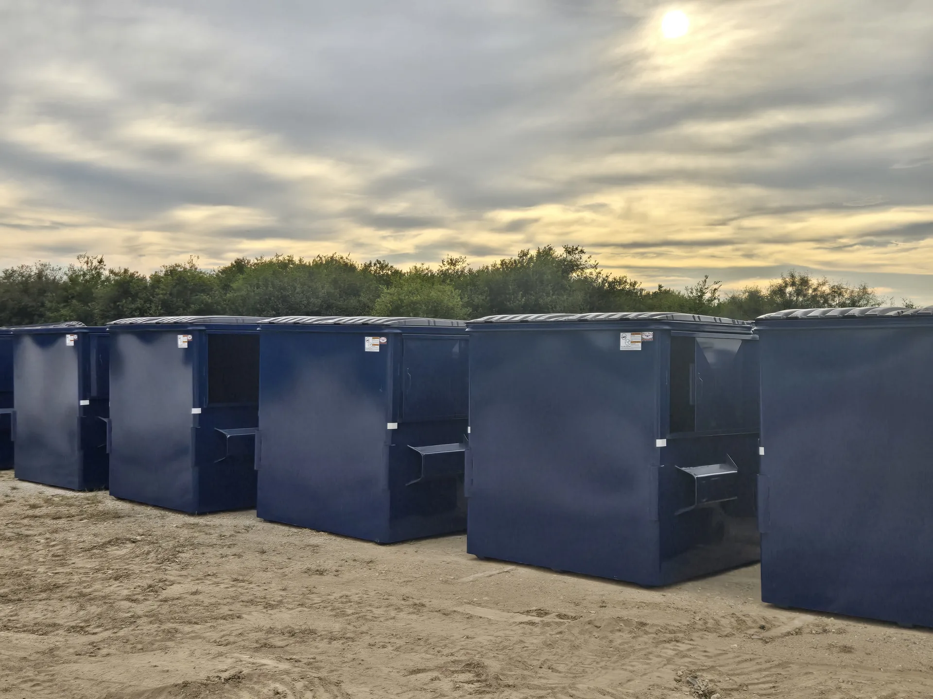 Commercial dumpsters lined up at facility